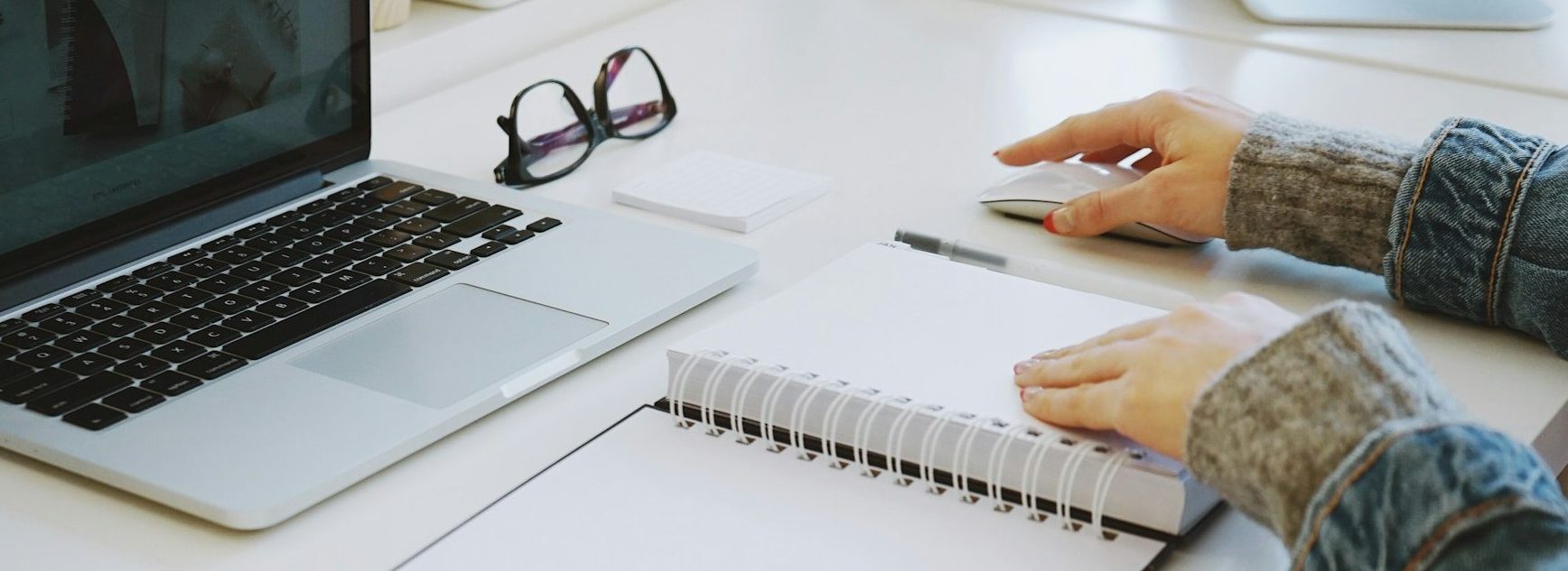 Laptop and notebook representing writing and professional services